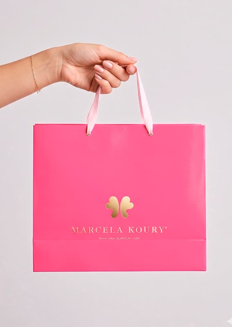 Bolsa cartulina rosa con logo dorado 32x26x10 cm - Marcela Koury