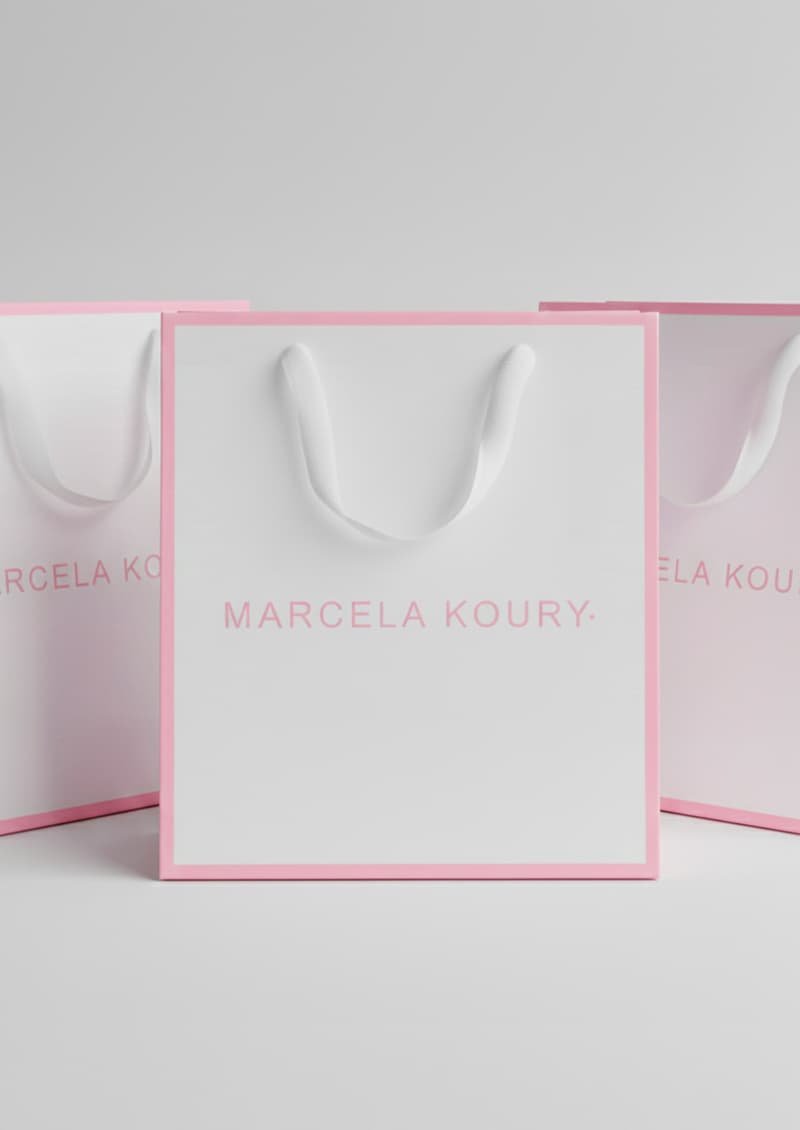 Detalle logo rosa en bolsa cartulina blanca para packaging y regalos - Marcela Koury